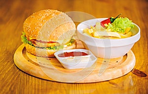 Cheat meal. Delicious burger with sesame seeds. Burger menu. High calorie snack. Hamburger and french fries and tomato