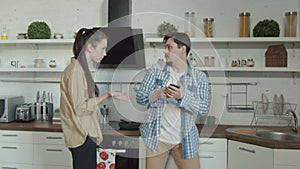 Cheater man talking on smartphone in kitchen