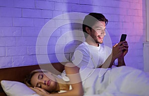 Cheating Boyfriend Texting On Cellphone While Girlfriend Sleeping In Bedroom