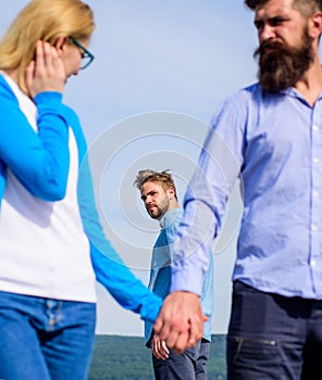 Cheating concept. Man found or detected girlfriend cheating him walking with another man. Man aggressive going attack