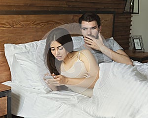 Cheating girlfriend. Shoked man looking at her mobile phone