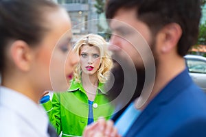 Cheating in marriage. Man looking other woman. Terribly jealous of them. Jealous woman look at couple in love on street