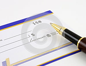 Closeup of blank check and pen