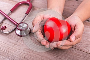 Check heart Concept : Woman hands holding red heart and stethosc