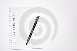 Check list. Square items are empty and checked with a tick. Squared notebook with black pen on a white background. Record ideas,