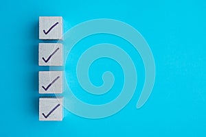 Check mark sign on white block checklist wooden background copy space. Checklist and questionnaire in business, education
