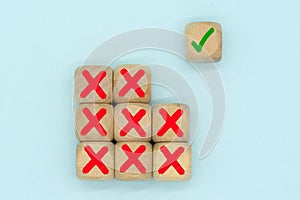 The check mark symbol on a wooden cube stack with wrong or cross icon. Making a right decision