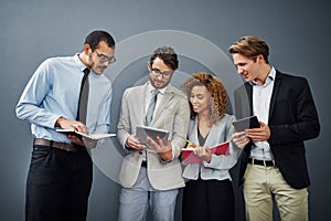 Check this out. a group of businesspeople using digital tablets and notebooks while waiting in line for a job interview.