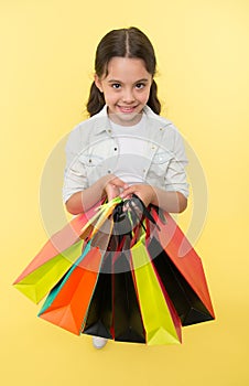 Check out her shopping packages. Child cute shopaholic with bunch shopping bags black friday total sale. Take shopping