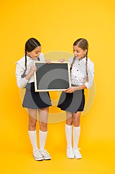 Check this out. School girls cute pupils hold blackboard copy space. Pupils community. Classmates initiative team yellow