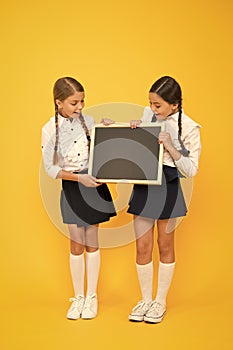 Check this out. School girls cute pupils hold blackboard copy space. Pupils community. Classmates initiative team yellow