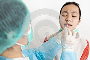 Check point for Coronavirus,Examining nasal mucus test from child girl,taking a swab inserted into the nostril,health check, photo