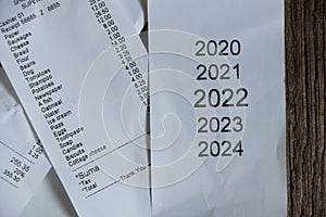 a check from the supermarket with a shopping list and a check with the dates of the years 2020 2021 2022 2023 2024, a