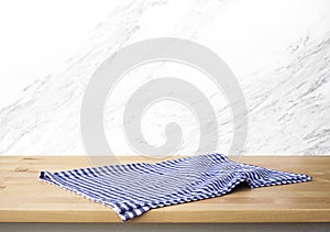 Checked tablecloth on wood with blur white marble brick background