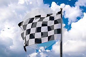 Checkered banner waving on blue sky and clouds