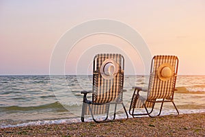 Checkered beach chairs on the seashore.