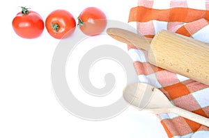 Checkered dishcloth, spoon, tomatoes and rolling pin isolated on white