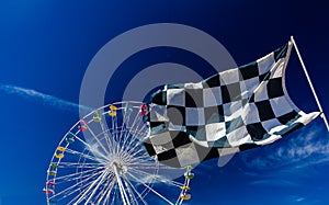Checkered Flag and Ferris Wheel Against Blue Sky