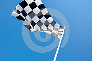 Checkered flag flying on blue sky background