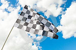 Checkered flag waving in the wind - clouds on background