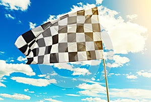 Checkered flag waving in the wind with sun flare visible