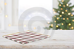 Checkered napkin on table and frosty window with christmas tree
