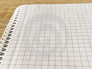 Checkered notebook with spiral. An open notepad for notes. Soft focus. Copy space. Blank blank page for your text
