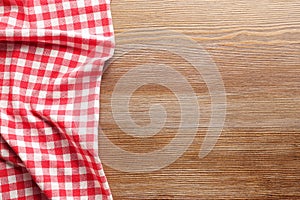 Checkered picnic tablecloth on wooden background,