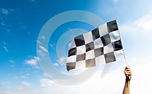 Checkered race flag in hand