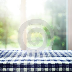 Checkered tablecloth texture top on blur of window and garden