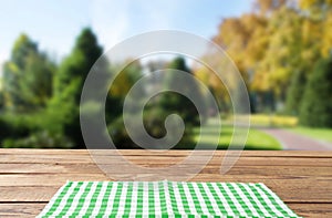 Checkered tablecloth top view with blur abstract green bokeh design garden. Selective focus. Copy space. Place for food and drink