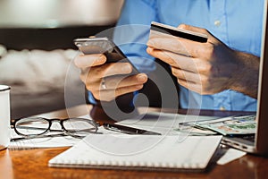 Checking bank account balance credit card payment, Income at home night. Cropped shot male hands paying bill online on smartphone photo