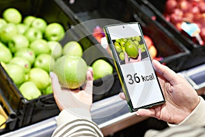 Checking calories on apple in store with smartphone