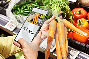 Checking calories on carrot vegetable with smartphone