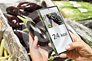 Checking calories on eggplant vegetable with smartphone