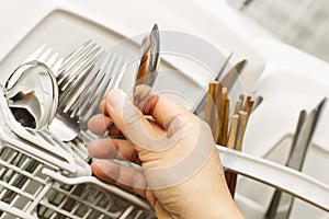 Checking for Cleanliness of Silverware from Dishwasher photo