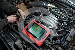 Checking the condition of the surface of the engine cylinders using an endoscope camera with a wireless display showing scratches