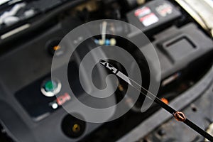 Checking Engine Oil Level with Dipstick in Car Engine Bay photo