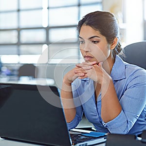 Checking her work before she submits it. a young businesswoman using a laptop at work.