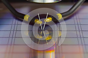 Close up of examining a sample of microchip transistor with probe station under the microscope in laboratory.A