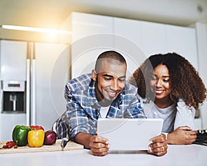 Checking out different recipes online. a young couple using a tablet together at home.