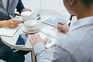 Checking stocks. Two business partners working on the laptop smiling cheerfully on a meeting at the local cafe - Image