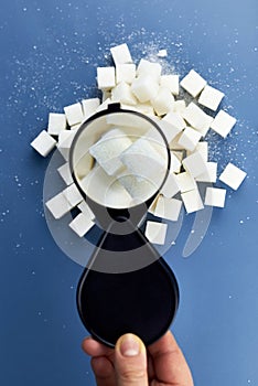 Checking sugar cubes with a magnifying glass