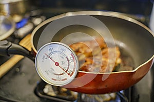 Checking the temperature with thermometer of fry chicken