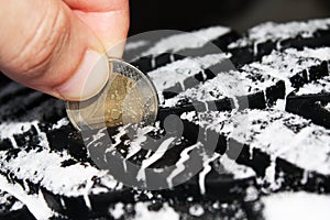 Checking tire tread depth with a two euro coin photo