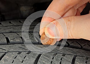 Checking tire tread depth/wear with a penny.  Tire safety and maintenance photo