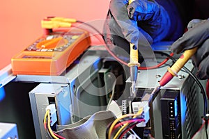 Checking the voltage with an ammeter in an old computer on the table