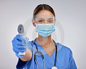 Checking your temperature could save you. a young female nurse holding a digital thermometer against a studio background