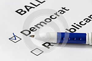 Checklist concept. Closeup of ballot paper with words Democrat and Republican and a pen on it. A checkmark for Democrat in the