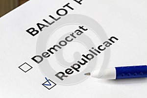 Checklist concept. Closeup of ballot paper with words Democrat and Republican and a pen on it. A checkmark for Republican in the